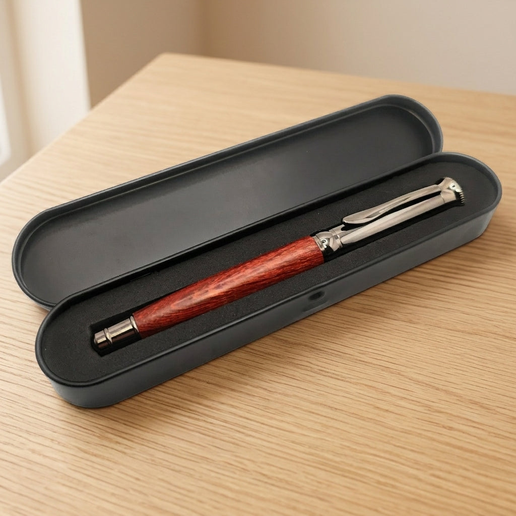 Stylo en bois à finitions métal gun dans son écrin en métal noir ouvert, intérieur en mousse noire, sur une table en bois – Weastyle Gravure