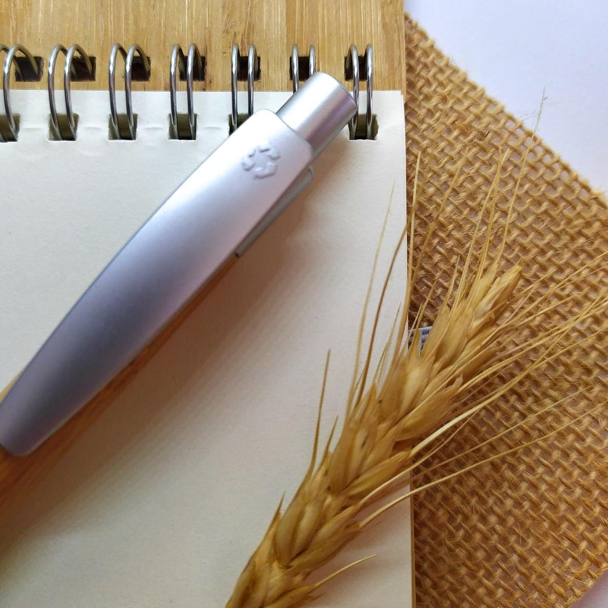 Gros plan sur la spirale du carnet en bambou, ses pages et le stylo assorti – Weastyle Gravure