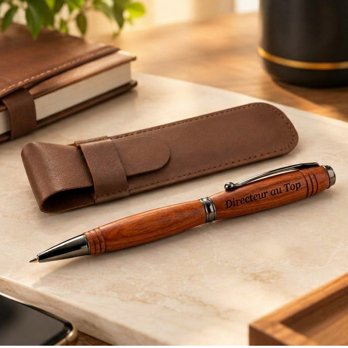 Stylo en bois gravé « Directeur au Top » posé à côté de son étui en PU marron sur un bureau – Weastyle Gravure